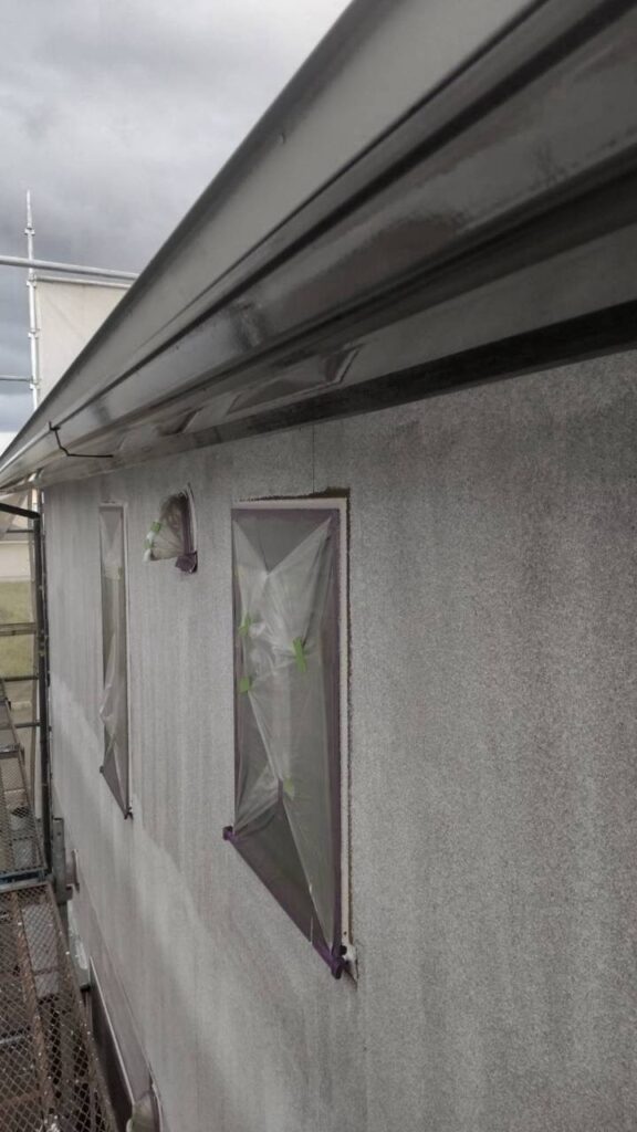 【養生】<br />
塗装作業に入る前に、塗料が付着してはいけない部分を養生しました。<br />
養生とは、塗装しない箇所を保護する作業です。<br />
外壁塗装では、塗料の飛散や付着を防ぎ、塗装する部分としない部分の境界を整えるために必要な工程になります。<br />
養生が不十分な場合、塗料が不要な場所に付着したり、仕上がりの境界が乱れたりする可能性があります。<br />
塗装そのものの品質だけでなく、周囲を汚さず丁寧に仕上げるためにも大切な作業です。
